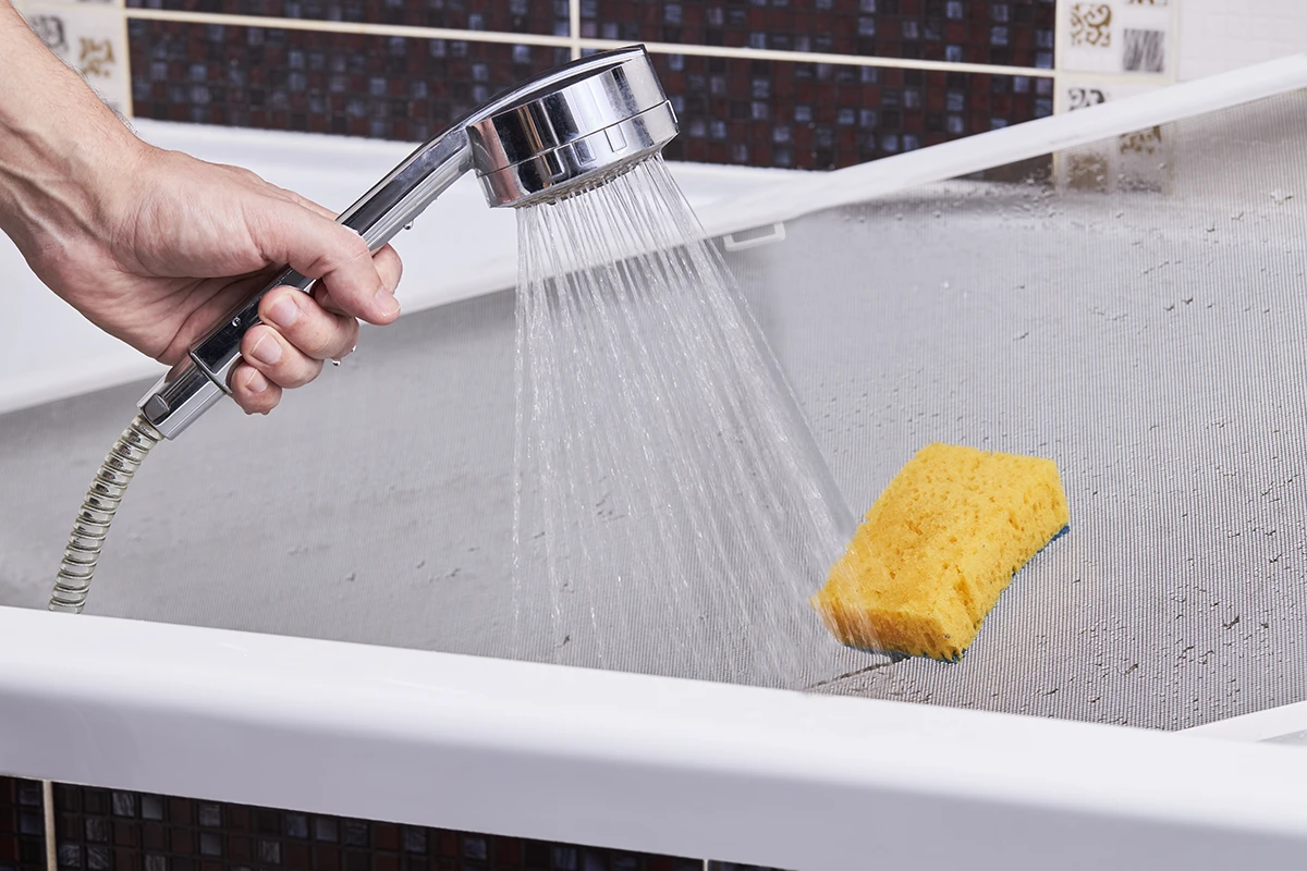 Clătirea plasei cu apă curată în cadă sau în cabina de duș și lăsarea ei la uscat complet